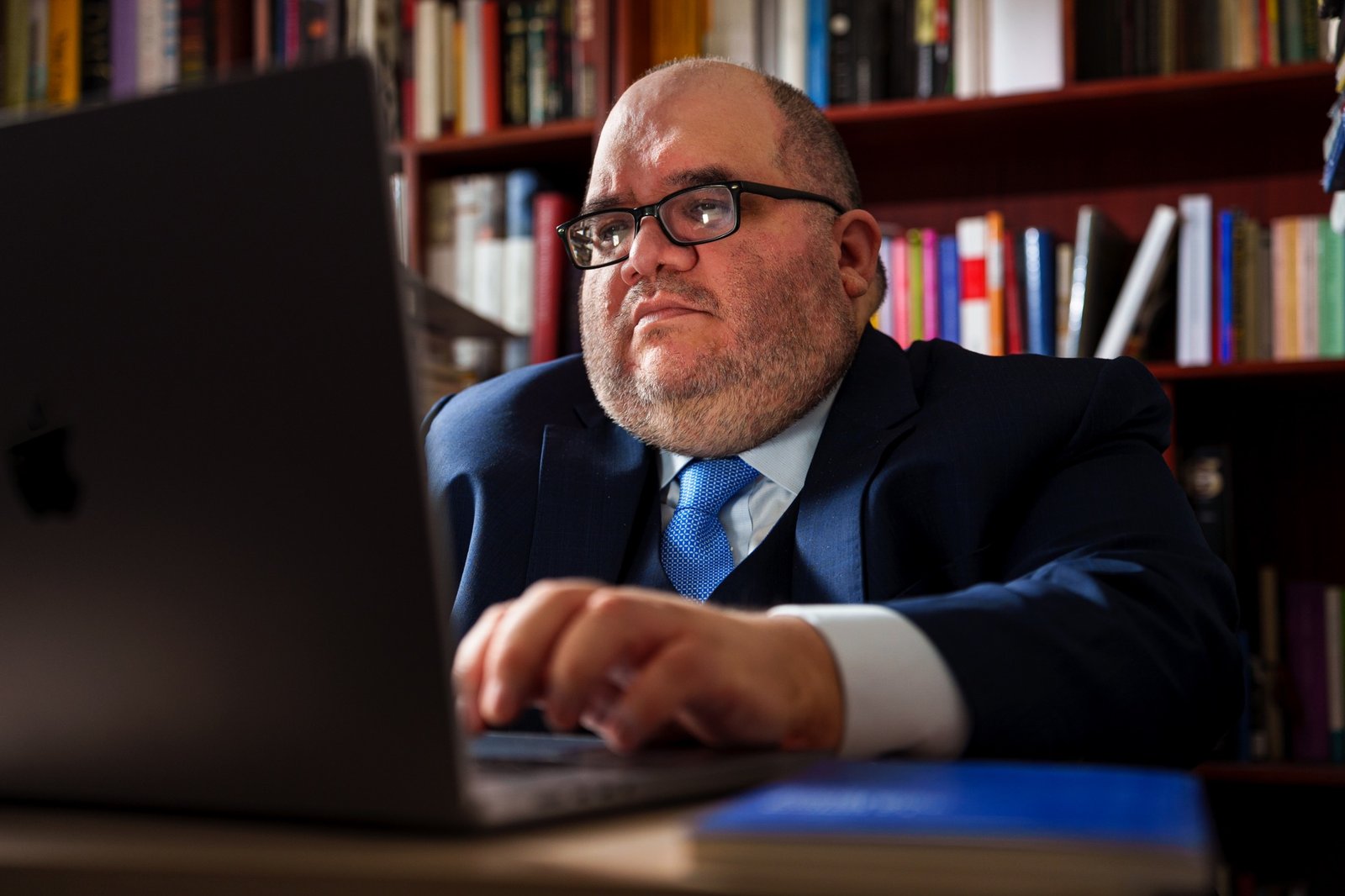 Abraham García Chávarri trabajando frente a su computadora en la biblioteca
