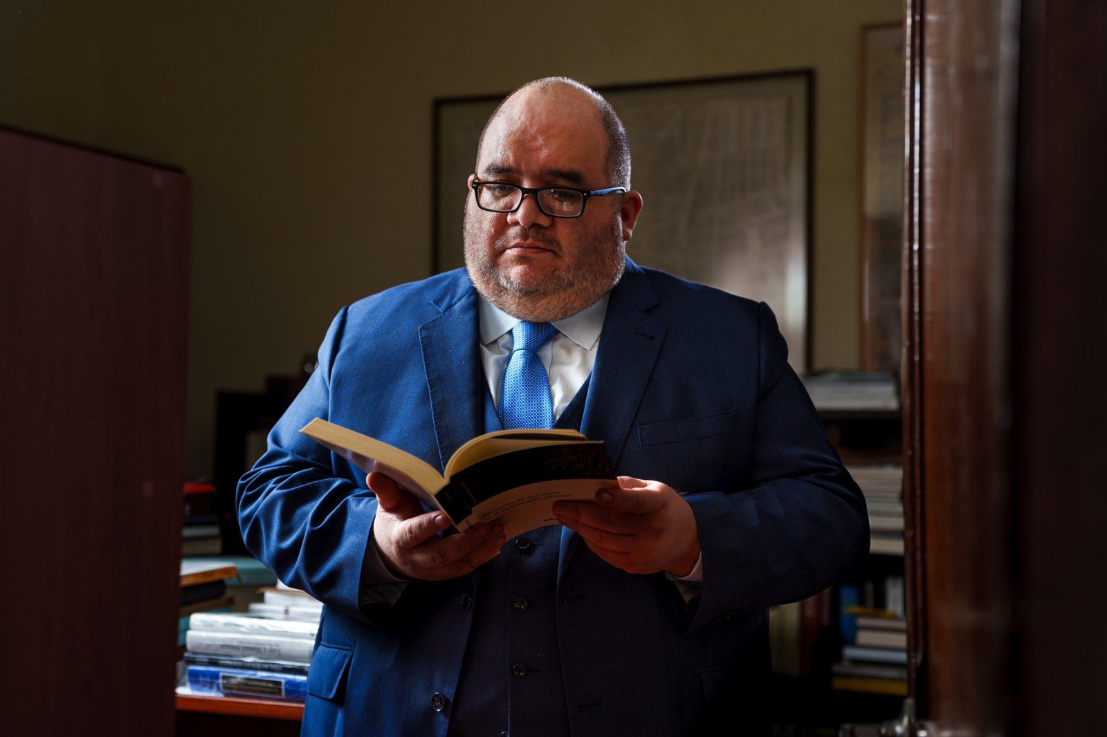 Abraham García Chávarri leyendo en su biblioteca